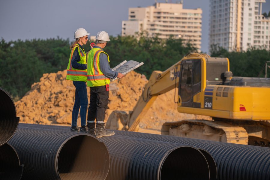 Construction surveyor or engineer working in pipe construction s