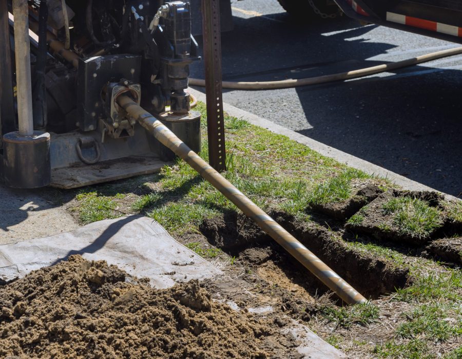 Low angle view of trenchless laying of communications, fiber optic and water pipes with horizontal directional drilling technology machine work process