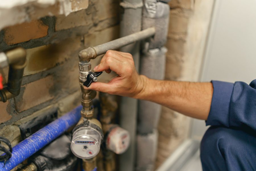 Plumber hand is going to turn off the valve of water pipe before repairing. High quality photo