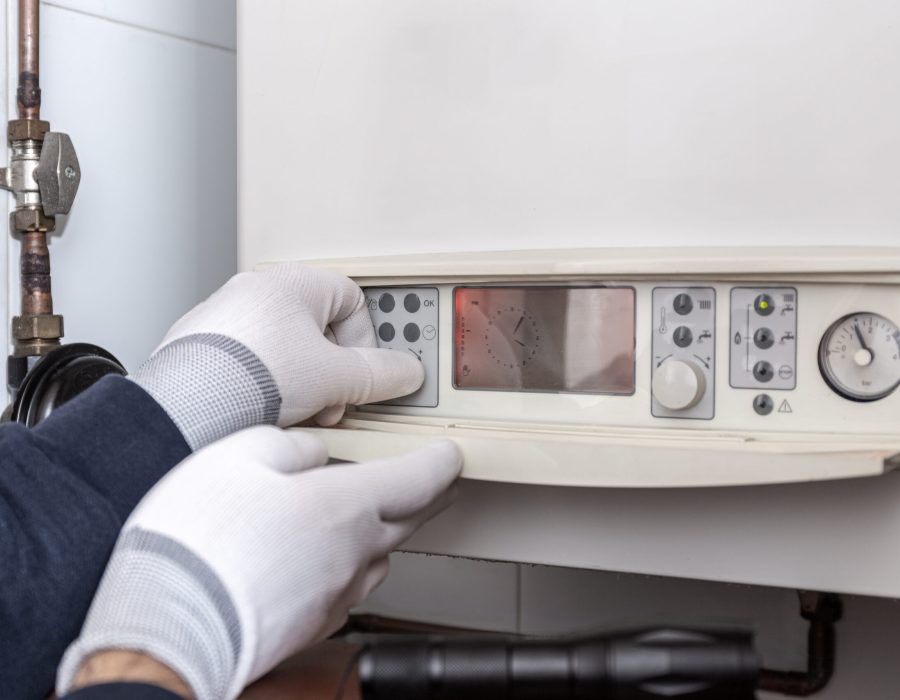 Technician servicing heating boiler in a house. Maintenance concept